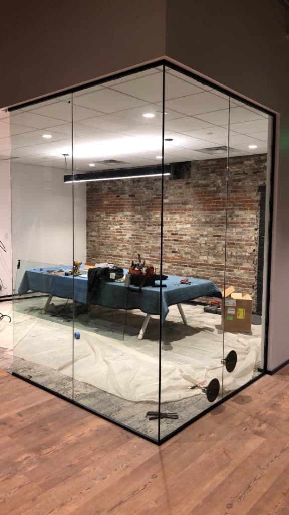Glass partition installation with brick interior and drop ceiling